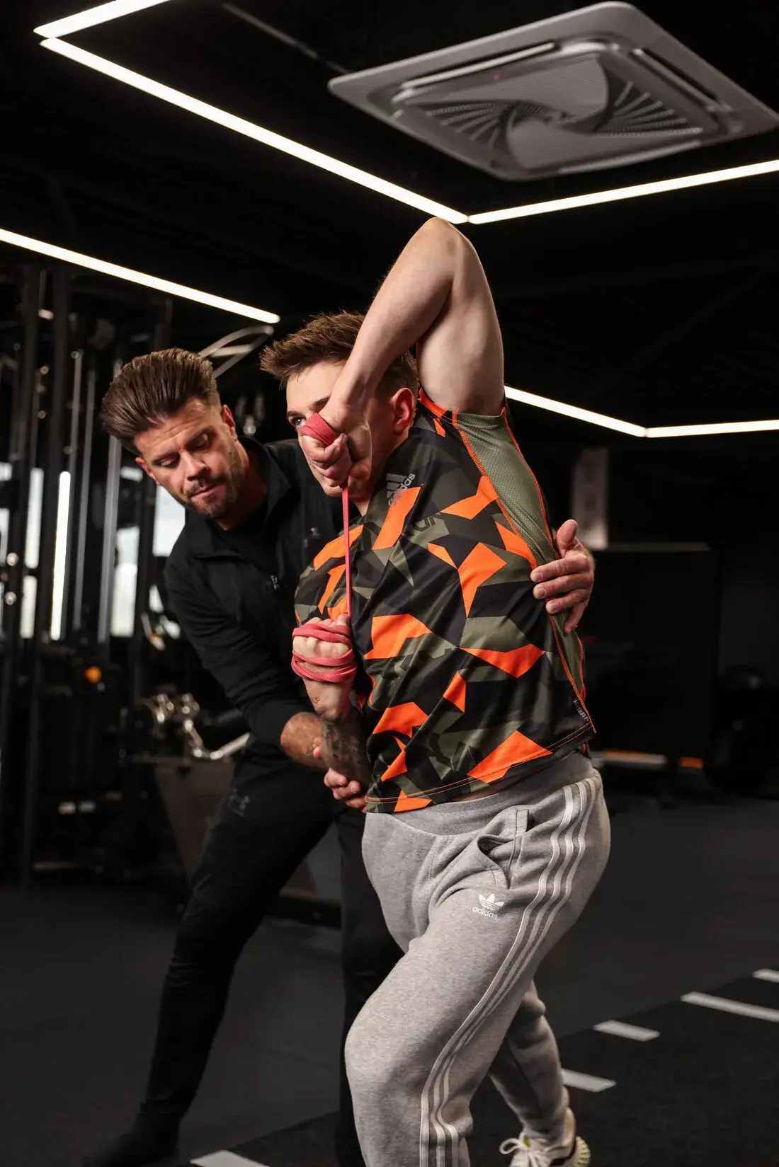 Trainer begeleidt een klant tijdens krachttraining